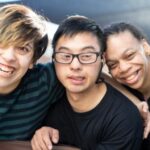 Young man being embraced by his friends