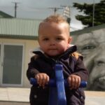 Young child outside on play equipment