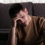 Man holding his head with his hand