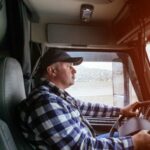 truck driver with cap on driving truck